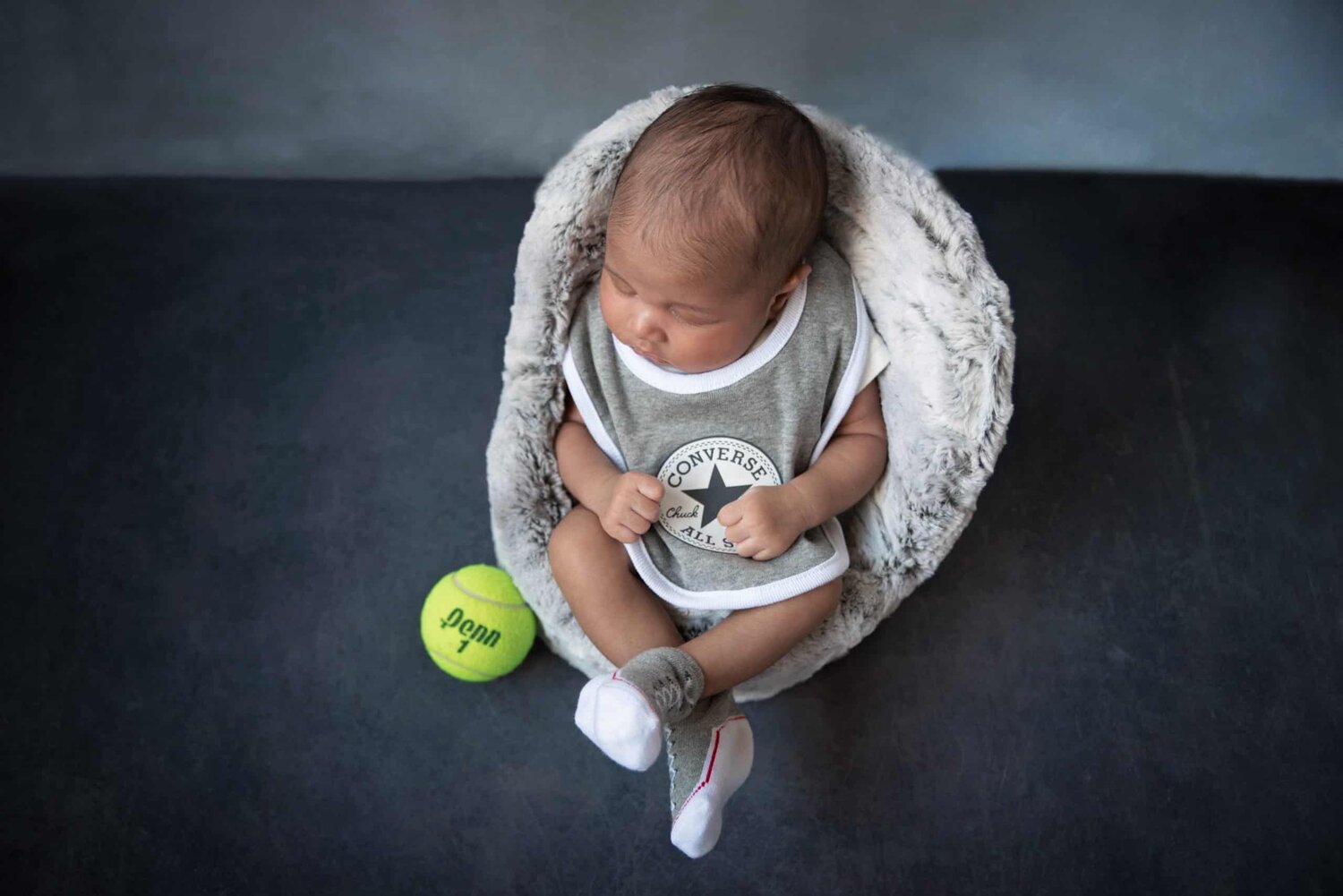 Top view of baby boy in sports bit sitting on chair - www.musenphotos.com - in-home newborn session - central New Jersey