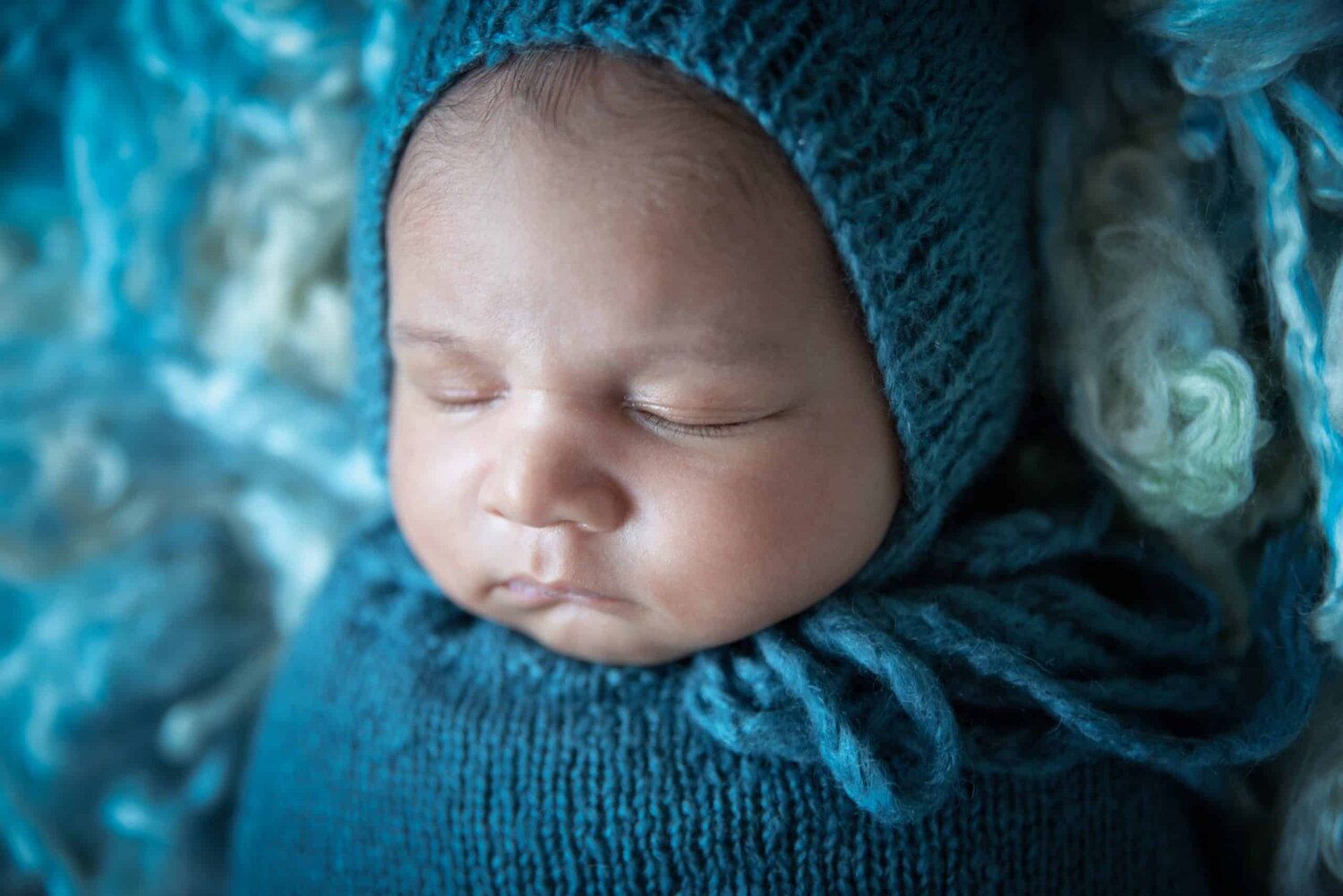 Close up shoot of baby face in blue bonnet - www.musenphotos.com - in-home newborn session - central New Jersey