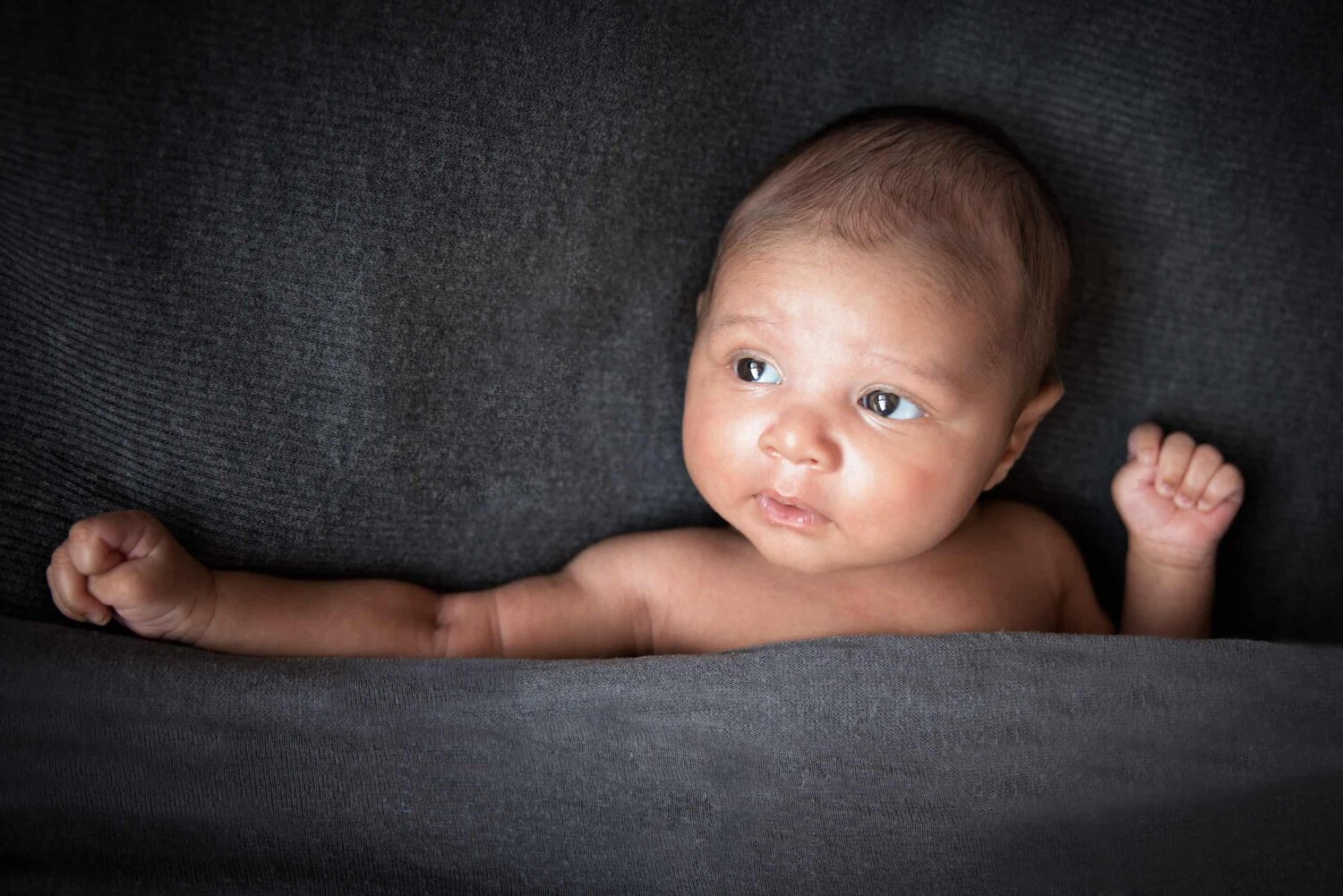One month new baby boy covered by grey blanket natural light - www.musenphotos.com - in-home newborn session - central New Jersey