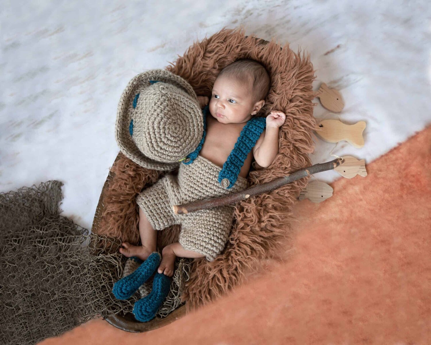 One month new baby boy in fisherman outfits with fish net and fish sticks - www.musenphotos.com - in-home newborn session - central New Jersey