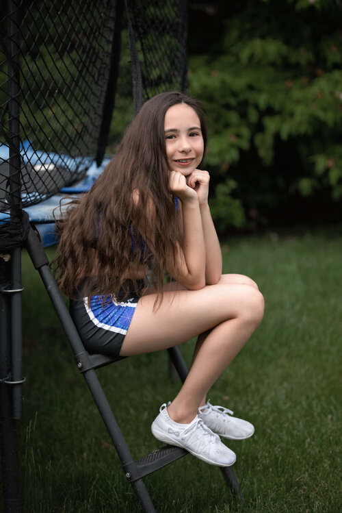 Tween girl sitting by trampoline
